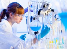 Life science laboratory. Attractive young PhD sscientist observing the blue indicator color shift after the solution  destillation.