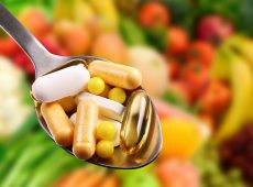 spoon with dietary supplements on fruits background